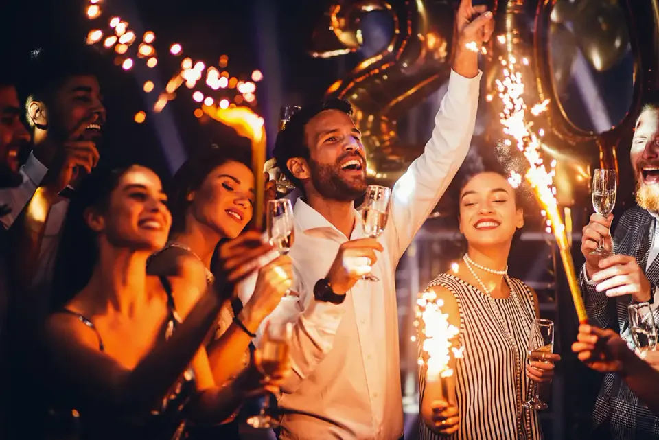 Gäste feiern mit Wunderkerzen und Sekt