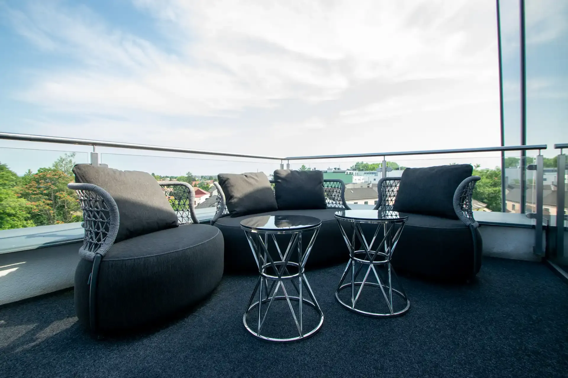 Dachterrasse mit Lounge-Sesseln und Blick über Leobersdorf